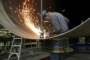 worker grinding large metal part