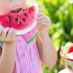 child eating a watermelon outside