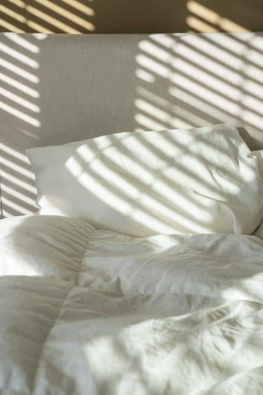 A pile of white pillows on a bed.