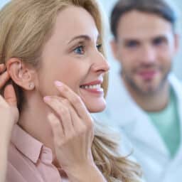 Happy woman looking at her new hearing aid